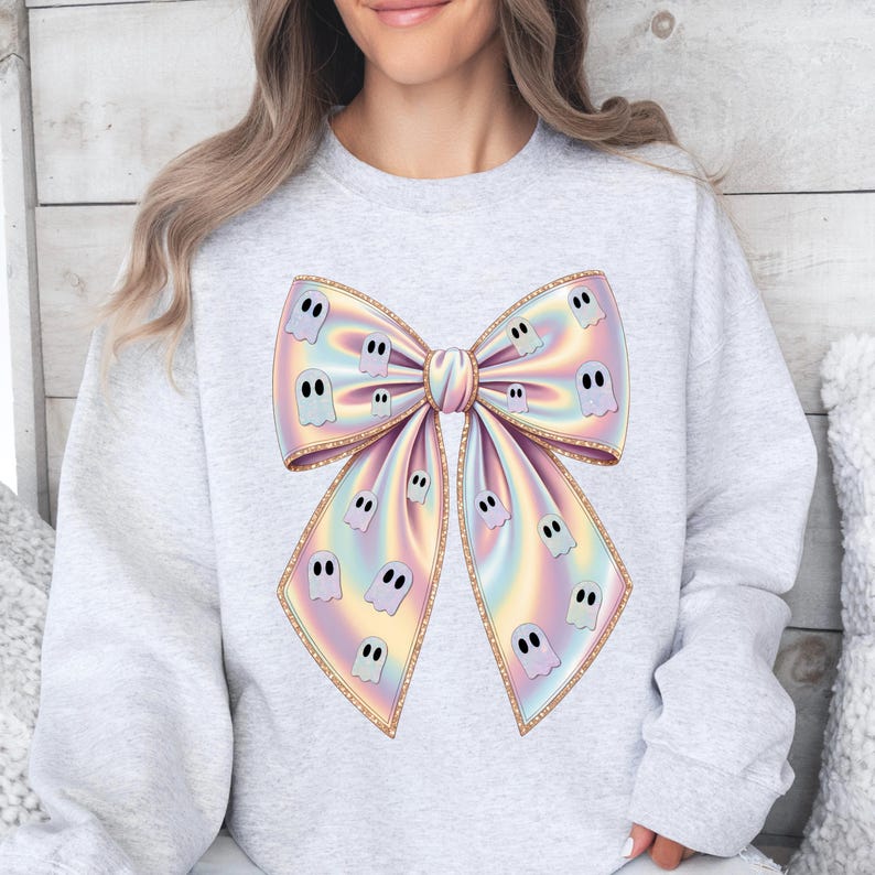Pastel rainbow bow with holographic shimmer, decorated with cute white ghost illustrations. Digital design with soft pink, blue, yellow, and lavender hues. The bow has glittery golden edges, perfect for Halloween-themed girl designs, shirts, sublimation projects, stickers, or party printables. Transparent background PNG file for crafting and digital use.