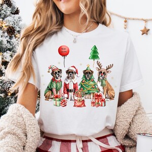 Festive Christmas design featuring four boxer dogs in holiday costumes. The boxer dogs are dressed as Santa Claus, a reindeer, a Christmas tree, and an elf, surrounded by Christmas gifts and decorations. High-quality digital PNG with transparent background, perfect for sublimation projects, holiday crafts, T-shirts, mugs, and unique Christmas gifts for boxer lovers and pet owners. Bright, detailed artwork that captures the joy of the holiday season.