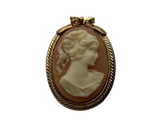 Broche/Colgante vintage de camafeo de concha de marfil en tono dorado con borde de cuerda e incrustación de coral en forma de lazo.