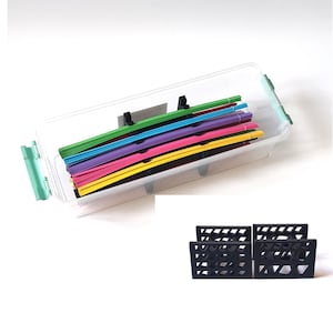 Puede incluir: Una caja de archivos de plástico transparente con un cierre verde, que contiene carpetas de colores. Debajo, se muestran cuatro organizadores de archivos geométricos negros, que ofrecen una solución de almacenamiento elegante para documentos y papeles.