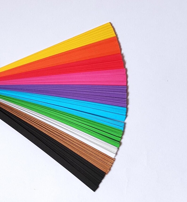 10 Colors Quilling Paper Strips - High Quality 180 gsm Rainbow Palette Set DIY Kit, Typography & 3D Effect, Perfect Craft Supplies. Quilling paper strips in various widths, including 3mm, 5mm, 7mm, and 10mm. The paper is 180 GSM and comes in a pack of 100 strips. The text on the image reads '180 GSM 100 strips/pack 3 mm, 5 mm, 7mm, 10 mm Best for - On-edge quilling, Lettering, Outline quilling and Structured designs'.