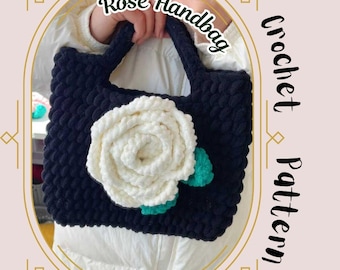 May include: A black crocheted handbag featuring a white crocheted rose and green leaves. The handbag has a simple design and is ideal for everyday use. The image also includes the text "Rose Handbag Crochet Pattern".