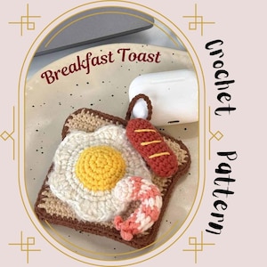 May include: Crochet pattern for a breakfast toast-themed phone case. The case features a crocheted toast with a fried egg, sausage, and shrimp. The text "Breakfast Toast" is visible in the image.