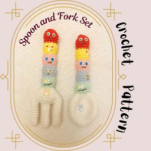 May include: A crochet spoon and fork set with colorful, stacked, smiling faces. The handles are a rainbow of red, yellow, pink, blue, and green. The spoon and fork heads are white, with a bunny design on the spoon.