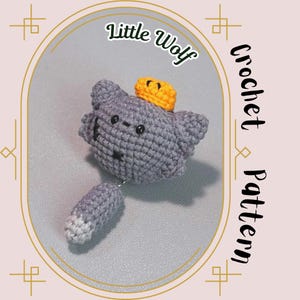 Może przedstawiać: Szary szydełkowy wilk z żółtą koroną, białym końcem ogona i tekstem "Little Wolf Crochet Pattern".