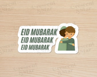 May include: A white sticker with a cartoon illustration of two people hugging. The text "Eid Mubarak" is repeated three times on the sticker.