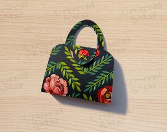 May include: A small black handbag with a floral pattern. The bag has a gold handle and a gold clasp.