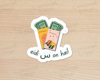 May include: A sticker with two red and pink envelopes with green dollar bills inside. The envelopes have the text "Eid Mubarak" on them. The sticker also has the text "eidi  on hai!" in green and white.