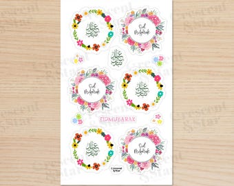 May include: A sheet of colorful Eid Mubarak stickers with floral wreaths and Arabic calligraphy. The stickers feature the phrase "Eid Mubarak" in English and Arabic.