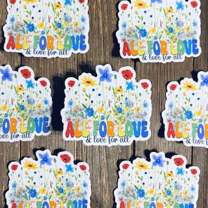 May include: A collection of stickers featuring a colorful floral design with the text "ALL FOR LOVE & love for all." The stickers showcase a variety of flowers in shades of red, yellow, blue, and white, set against a white background.