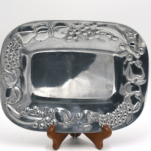 May include: A silver serving tray with a raised design of fruit and grapes around the edge.