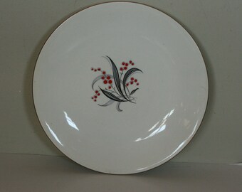 May include: White ceramic dinner plate with a gold rim and a floral design featuring red berries and black and gray leaves.