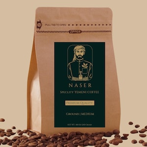 May include: A brown paper bag of "NASER" specialty Yemeni coffee. The bag features a dark green label with an illustration of a man and the text "PREMIUM QUALITY" and "GROUND | MEDIUM". The net weight is 8.8 oz (250 grams).