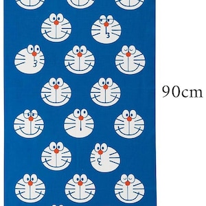Può includere: Asciugamano rettangolare blu con un motivo ripetuto del volto di Doraemon. L'asciugamano misura 34 cm di larghezza e 90 cm di lunghezza. Il design presenta il volto di Doraemon con naso rosso, viso bianco e corpo blu. Testo giapponese incluso.