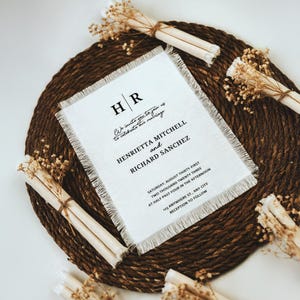 Puede incluir: Una invitaci&oacute;n de boda blanca con borde deshilachado, que presenta las iniciales de la pareja "HR" y el texto "We invite you to join us to celebrate our marriage Henrietta Mitchell and Richard Sanchez Saturday, August Thirty-First Two Thousand Twenty Three at Half Past Four in the afternoon 133 Anywhere St, Any City Reception to Follow"