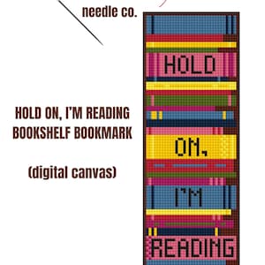 May include: A cross-stitch pattern for a bookshelf bookmark with the text "HOLD ON, I'M READING" in colorful, pixelated letters. The pattern is designed by the Graceful Needle Co.
