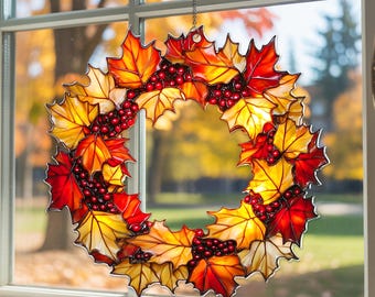 Op de afbeelding: Een decoratieve krans met esdoornbladeren in rood, oranje en geel, met trossen rode bessen. De krans hangt voor een raam en is een herfstthema decoratie.