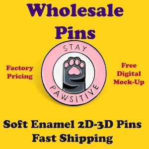 Puede incluir: Un pin redondo de esmalte rosa y blanco con un diseño de pata de gato. El pin tiene las palabras "STAY PAWSITIVE" y "Wholesale Pins" en negrita. El fondo es amarillo.