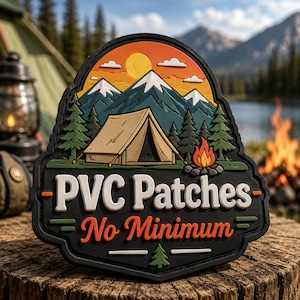 May include: A shield-shaped PVC patch featuring a camping scene with a tan tent, green pine trees, a campfire, and snow-capped mountains under a yellow sun. The black base displays the white text PVC Patches and orange text No Minimum.