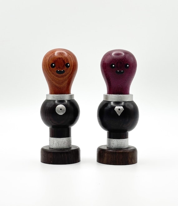 A hand-carved wooden alien figurine that feels like a tiny outsider-art sculpture — the kind of desk piece that makes visitors pick it up and ask where you got it.