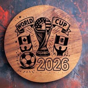 May include: A round wooden plaque with a World Cup theme. The design includes a trophy, soccer ball, flags of Canada and Mexico, and the text "World Cup 2026". The design is in black.