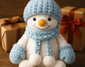 Puede incluir: Un muñeco de nieve de peluche hecho a mano con gorro, bufanda y mitones azules, con nariz de zanahoria y ojos de botón negros. El muñeco de nieve está rodeado de cajas de regalo envueltas con papel marrón y lazos, creando una escena festiva.