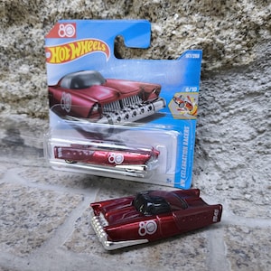 Puede incluir: Un coche de juguete rojo metalizado con el número "80" y la inscripción "1945". El coche forma parte de la serie Hot Wheels 80th Celebration Racers, presentado con su embalaje original.