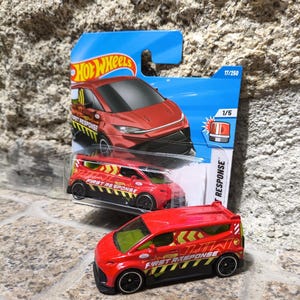 Puede incluir: Coche de juguete Hot Wheels rojo con la inscripción "First Response". El coche tiene ruedas negras y un diseño negro y amarillo. El embalaje es azul e incluye el logotipo de Hot Wheels y el número 17/250.