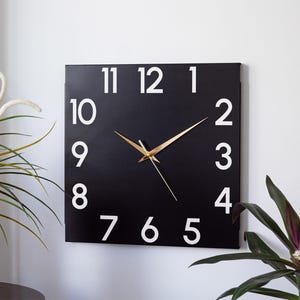 Reloj de pared cuadrado moderno de metal negro, silencioso, de estilo minimalista.