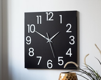 Moderne schwarze quadratische Wanduhr, minimalistische Wohnkultur, stille Uhr