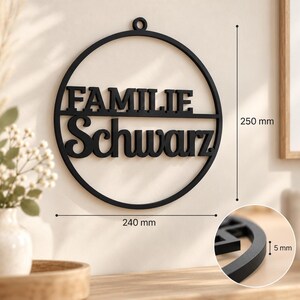 May include: A black circular wall sign featuring the text FAMILIE Schwarz. The sign has a small hanging loop at the top. Dimension lines indicate a height of 250 mm, a width of 240 mm, and a thickness of 5 mm shown in a circular inset detail.