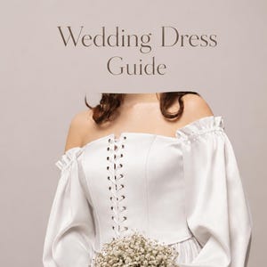 May include: A white off-the-shoulder wedding dress with long sleeves and a lace-up bodice. The dress has a flowing skirt and is paired with a bouquet of white flowers. The text "Wedding Dress Guide" is at the top.