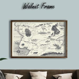 Könnte beinhalten: Ein gerahmter Karten-Druck mit einem Walnussrahmen hängt über einem braunen Sofa. Die Karte ist in Schwarzweiß gehalten und zeigt eine Fantasiewelt mit Bergen, Wäldern und Flüssen. Der Text "Walnut Frame" steht über der Karte.