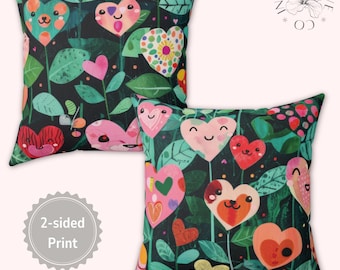 May include: Two decorative cushions with a whimsical floral design featuring smiling heart-shaped flowers in various colours against a dark background. The cushions have a 2-sided print, adding versatility to home decor.