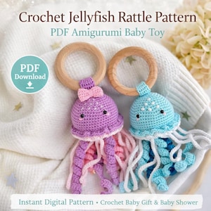 Può includere: Due sonagli per bambini a forma di medusa all'uncinetto. Uno è viola con tentacoli rosa e bianchi, l'altro è blu con tentacoli bianchi. Entrambi hanno manici ad anello in legno e sono adornati con fiocchi. Il testo recita "Crochet Jellyfish Rattle Pattern" e "PDF Amigurumi Baby Toy".