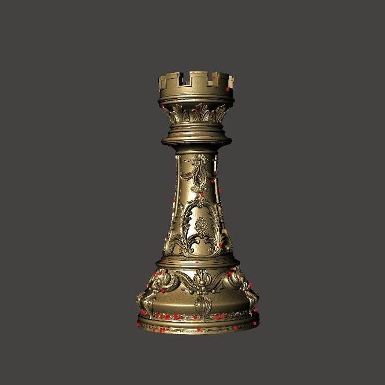 May include: A gold-colored rook chess piece with intricate floral and scrollwork detailing. The rook has a crenellated top and a detailed base. The piece is set against a dark gray background, highlighting its ornate design.