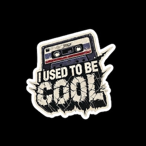 May include: A vintage-style sticker with a cracked, distressed background. The sticker features a cassette tape with the text "I USED TO BE COOL" in a bold, distressed font.