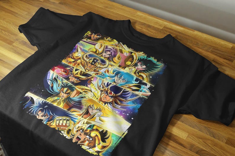 May include: Black t-shirt featuring a colorful graphic of anime characters. The design showcases multiple figures with detailed armor and dynamic poses, set against a vibrant, cosmic background. The artwork is a collage of various characters.
