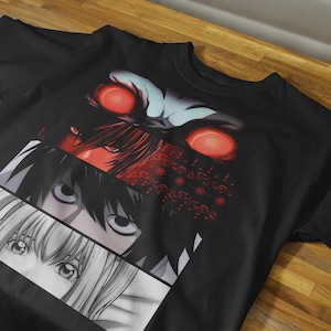 May include: Black t-shirt featuring a graphic design of anime character eyes in red, black, and white. The design is split into three horizontal sections. The top section has red eyes and a dark background.