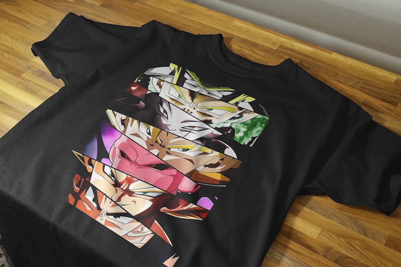 May include: Black t-shirt featuring a graphic design of various anime character faces in a fragmented, layered style. The design incorporates a range of colors, including orange, pink, yellow, and green. The shirt is made of a soft material.