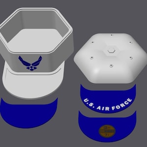 Peut inclure: Un chapeau hexagonal gris clair avec un emblème et du texte bleu de l'US Air Force. Le chapeau est présenté démonté, avec un bord bleu et une pièce supérieure avec de petites indentations circulaires. Le texte "U.S. AIR FORCE" est visible sur le bord.