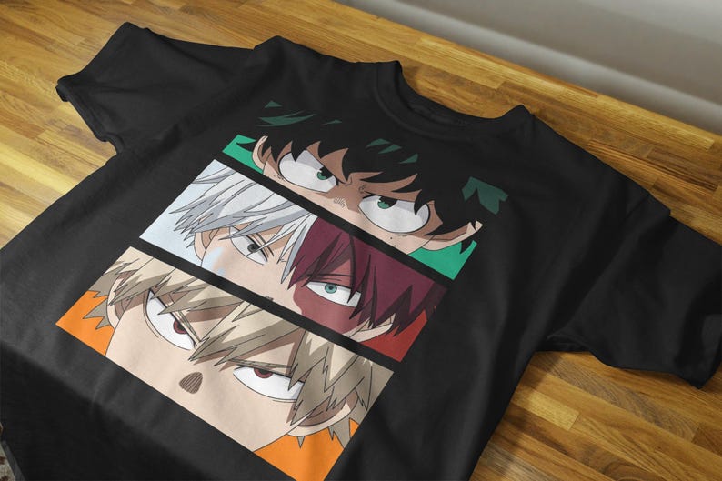 May include: Black t-shirt featuring a graphic of three anime character faces. Each face is in a separate rectangular panel with different colored backgrounds. The characters have distinct eye colors and hairstyles.