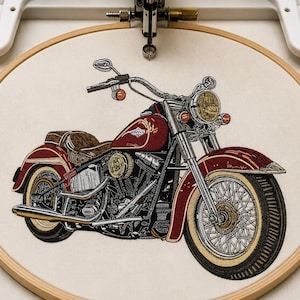 May include: An embroidery design of a red motorcycle with a brown seat, chrome handlebars, and spoked wheels, secured within a circular wooden embroidery hoop. The detailed machine-stitched graphic features a headlight, engine, and exhaust pipe.