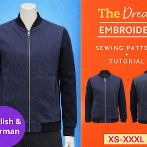 Op de afbeelding: Marineblauwe bomberjack met een gewatteerd patroon op de voorkant en zwarte mouwen, getoond op een mannequin. De afbeelding bevat de tekst "The Dream Embroidery" en "Sewing Pattern + Tutorial". Maten: XS-XXXL.