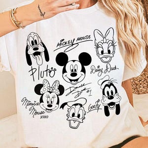 May include: White t-shirt with black and white cartoon images of Mickey Mouse, Minnie Mouse, Pluto, Goofy, Donald Duck, and Daisy Duck. Each character has their name written in cursive next to them.