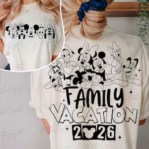 May include: Cream-colored t-shirt featuring a black and white graphic of Disney characters, including Mickey and Minnie Mouse, and the text "FAMILY VACATION 2026". The front of the shirt shows the characters' faces.