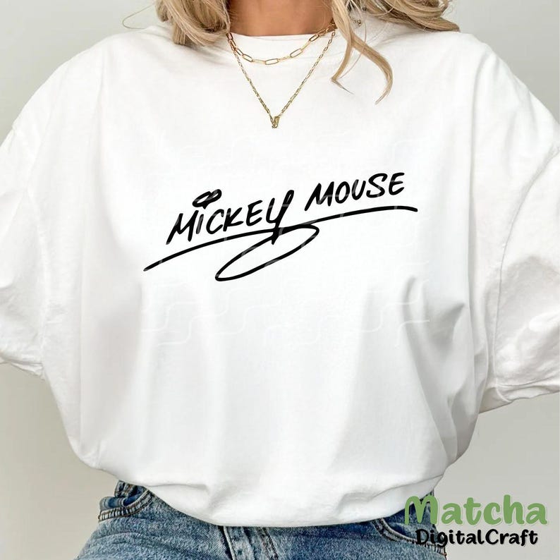 Puede incluir: Camiseta blanca con un gr&aacute;fico negro que dice "Mickey Mouse" en un estilo de escritura a mano.