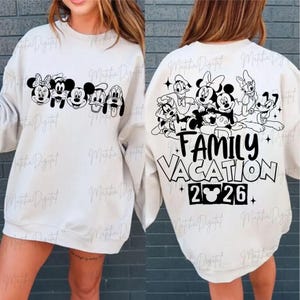May include: Off-white sweatshirt featuring a black graphic of Disney characters across the front and back. The front displays Mickey, Minnie, and friends. The back says "Family Vacation 2026".