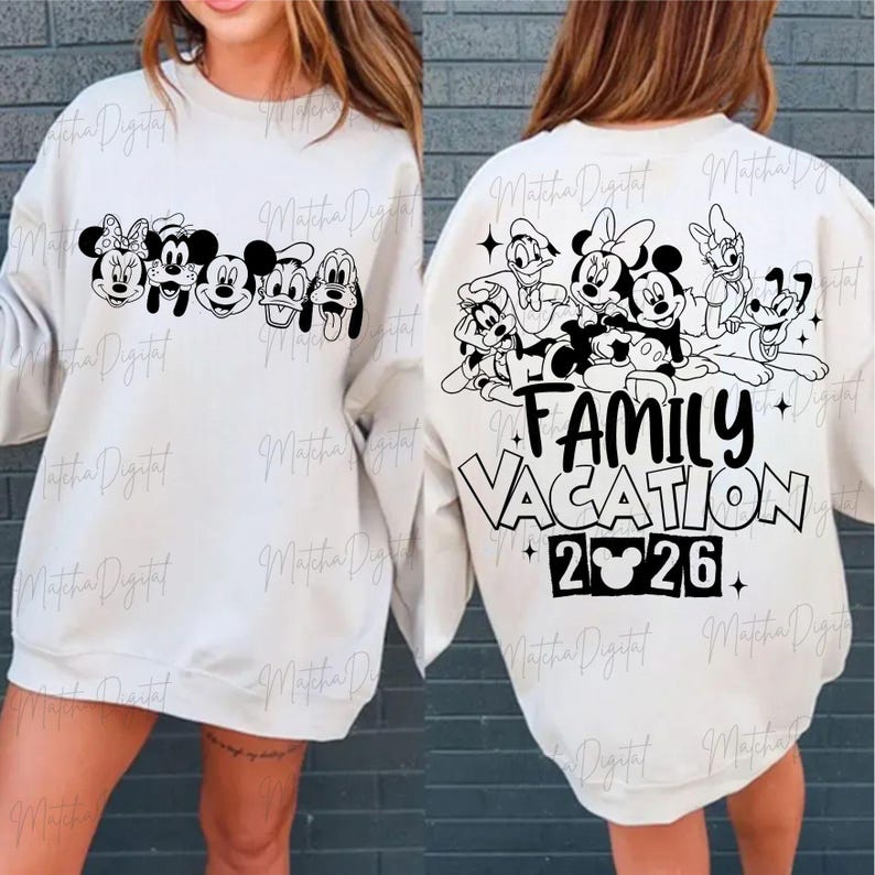 May include: Off-white sweatshirt featuring a black graphic of Disney characters across the front and back. The front displays Mickey, Minnie, and friends. The back says "Family Vacation 2026".