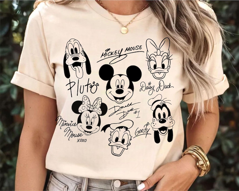 May include: A white t-shirt with black cartoon images of Mickey Mouse, Minnie Mouse, Donald Duck, Daisy Duck, Goofy, and Pluto. Each character has their name written in cursive underneath their image.